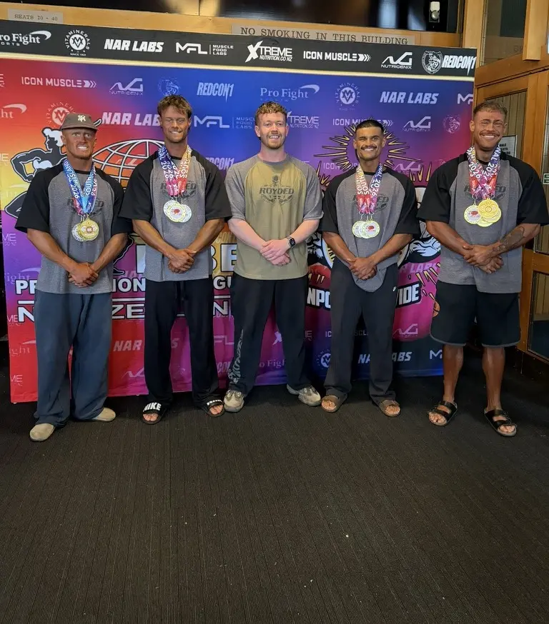 James with four of his athletes in Team Ecroyd tees, wearing their medals
