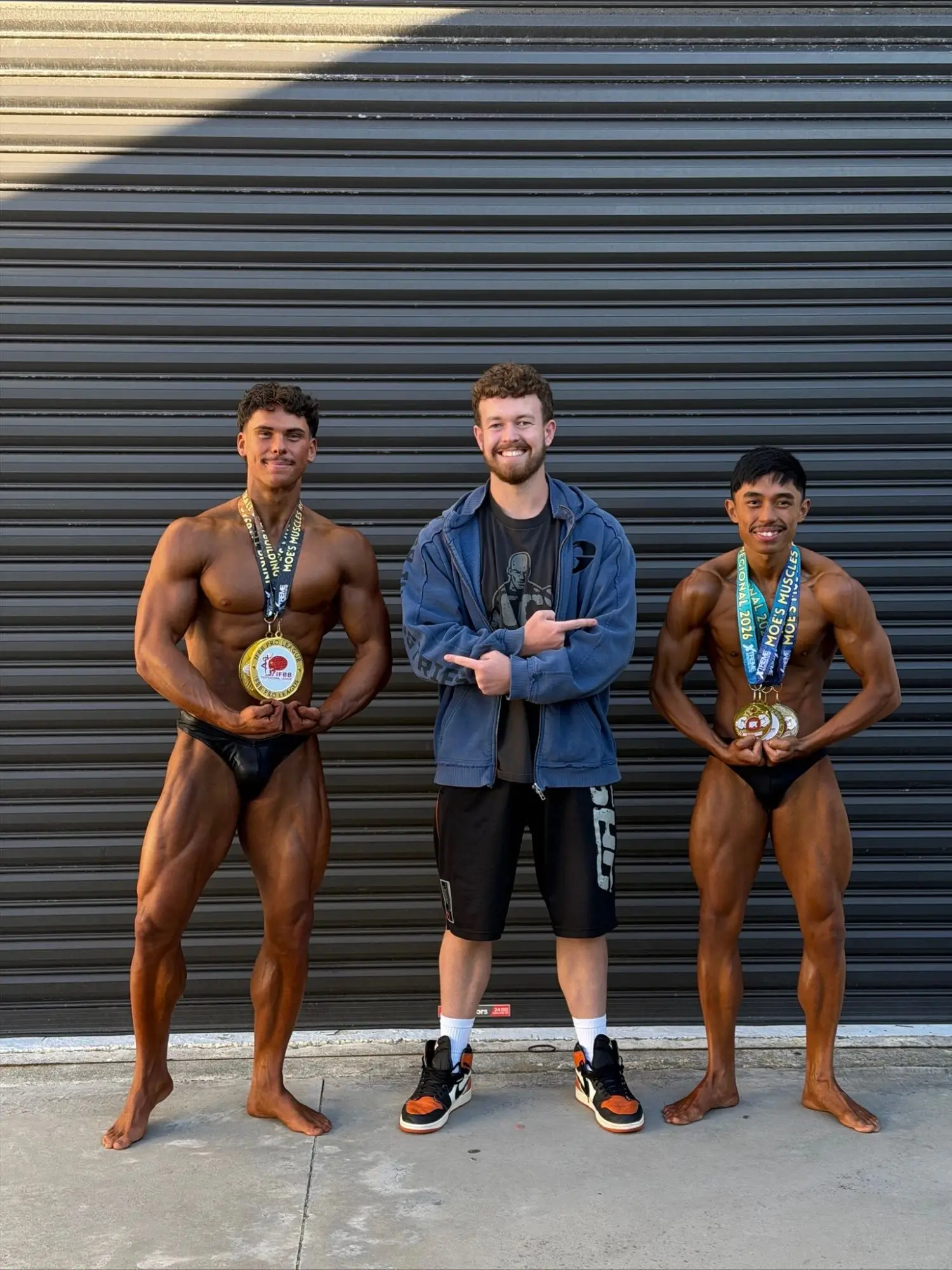James with two of his athletes wearing their medals