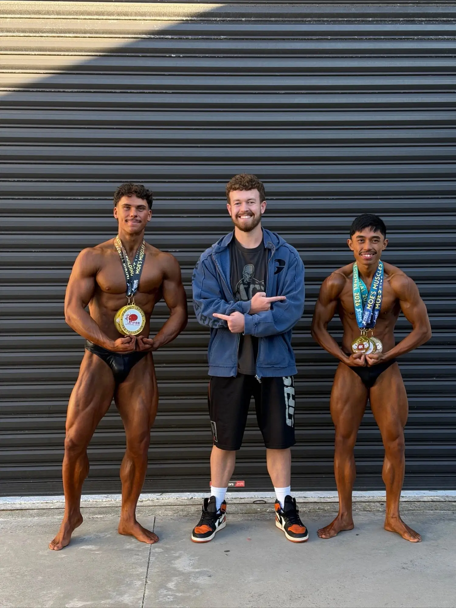 James with two of his athletes wearing their medals